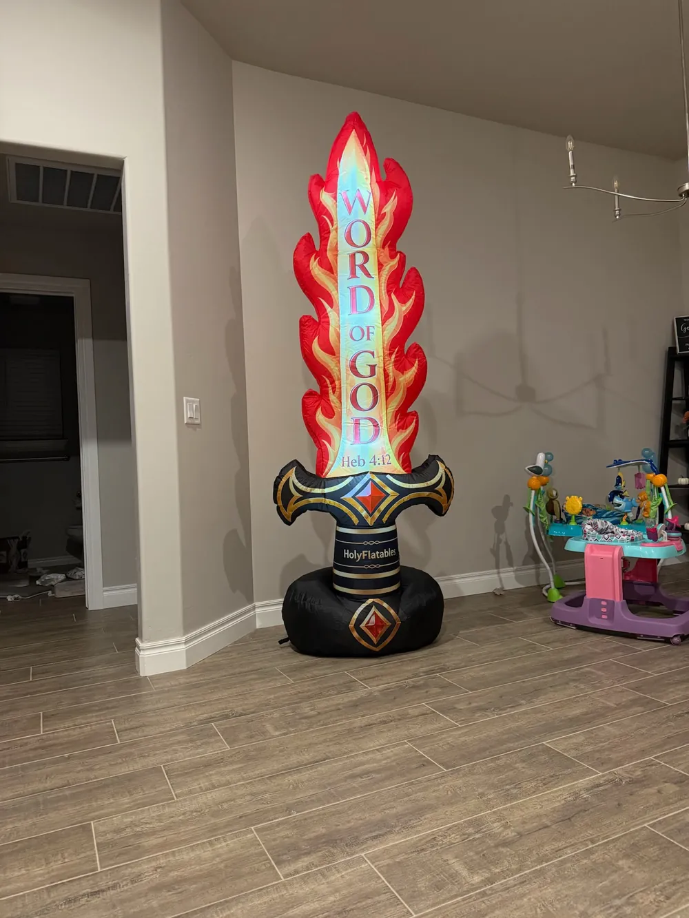 The Flaming Sword inflatable standing in a home, with the words Word of God and Heb 4:12 on the glowing blade